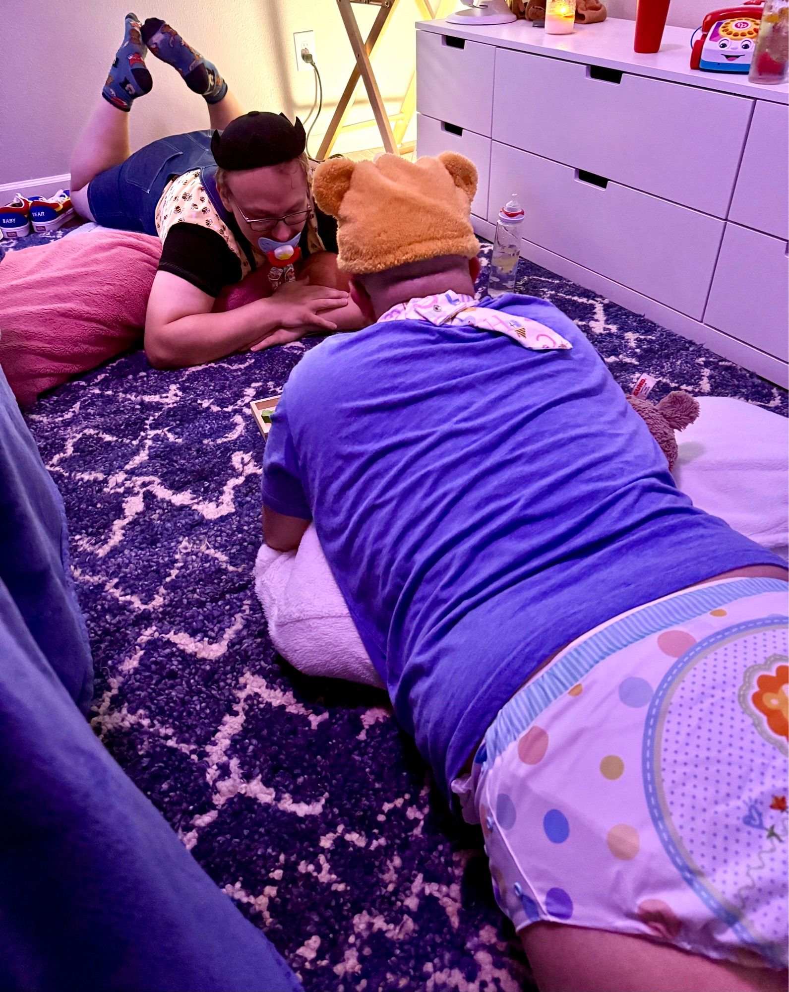 Two diapered boys on the floor putting together a puzzle