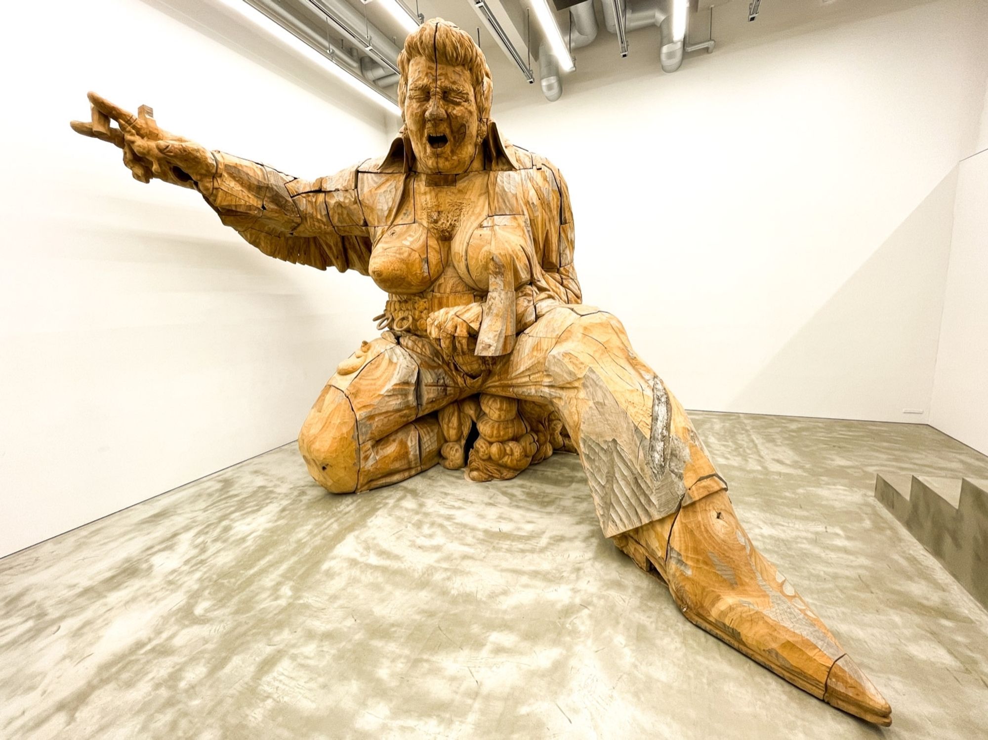 Osamu Mori's Jamboree EP (2014). It's a carved wooden sculpture, like 4m x 4m x 4m, Elvis has an open shirt, large breasts, is holding the end of an erection and is squatting over coils of possibly excrement? possibly his own intestines?