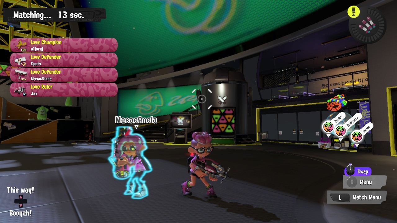 A screenshot of the Splatoon 3 lobby, two octolings are on screen. One is a hologram that says MasaeAnela above her head. they are both on Team Love in the Money vs Fame vs Love Splatfest.