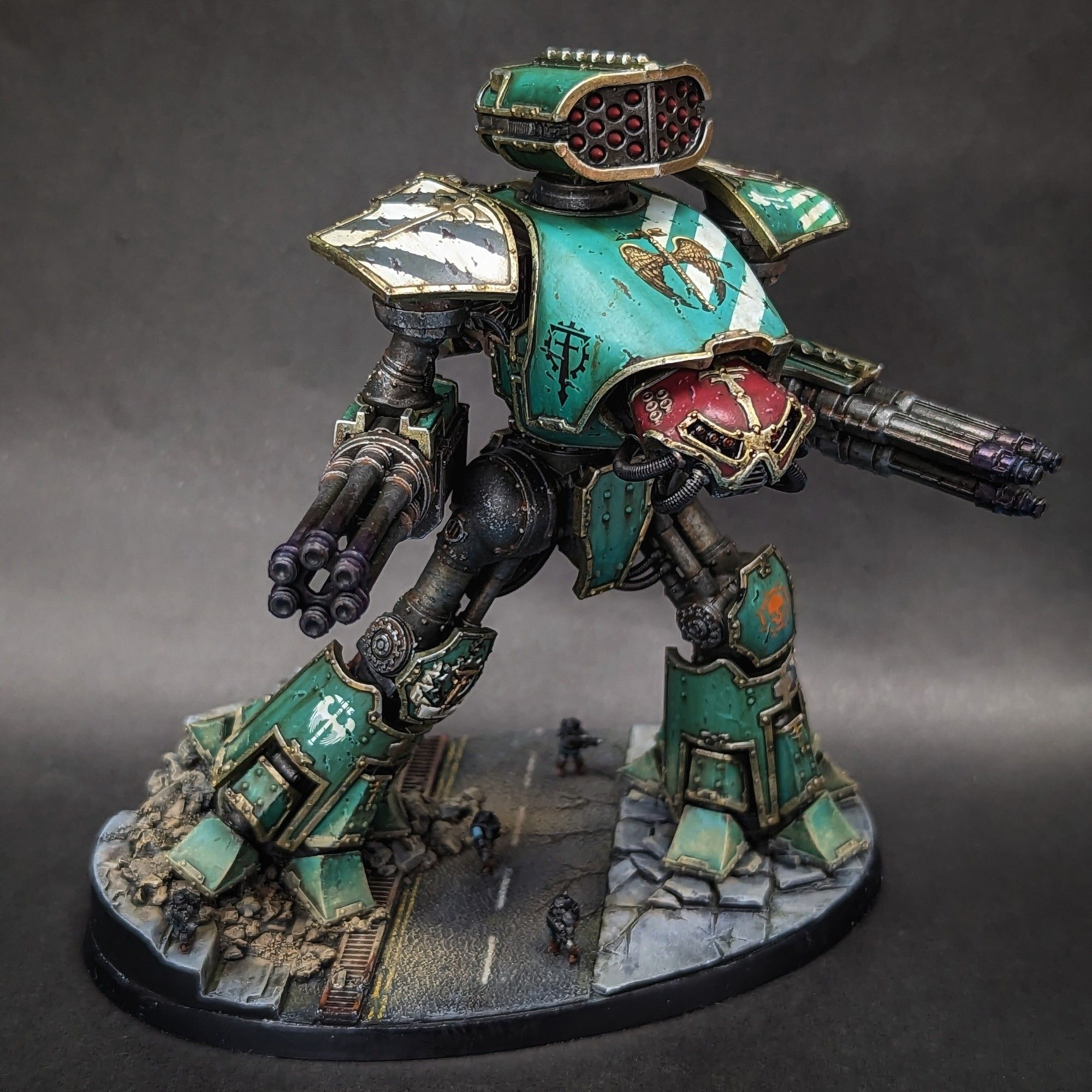 A Reaver Titan of the Legio Krytos strides across a street. Adeptus Titanicus scale.