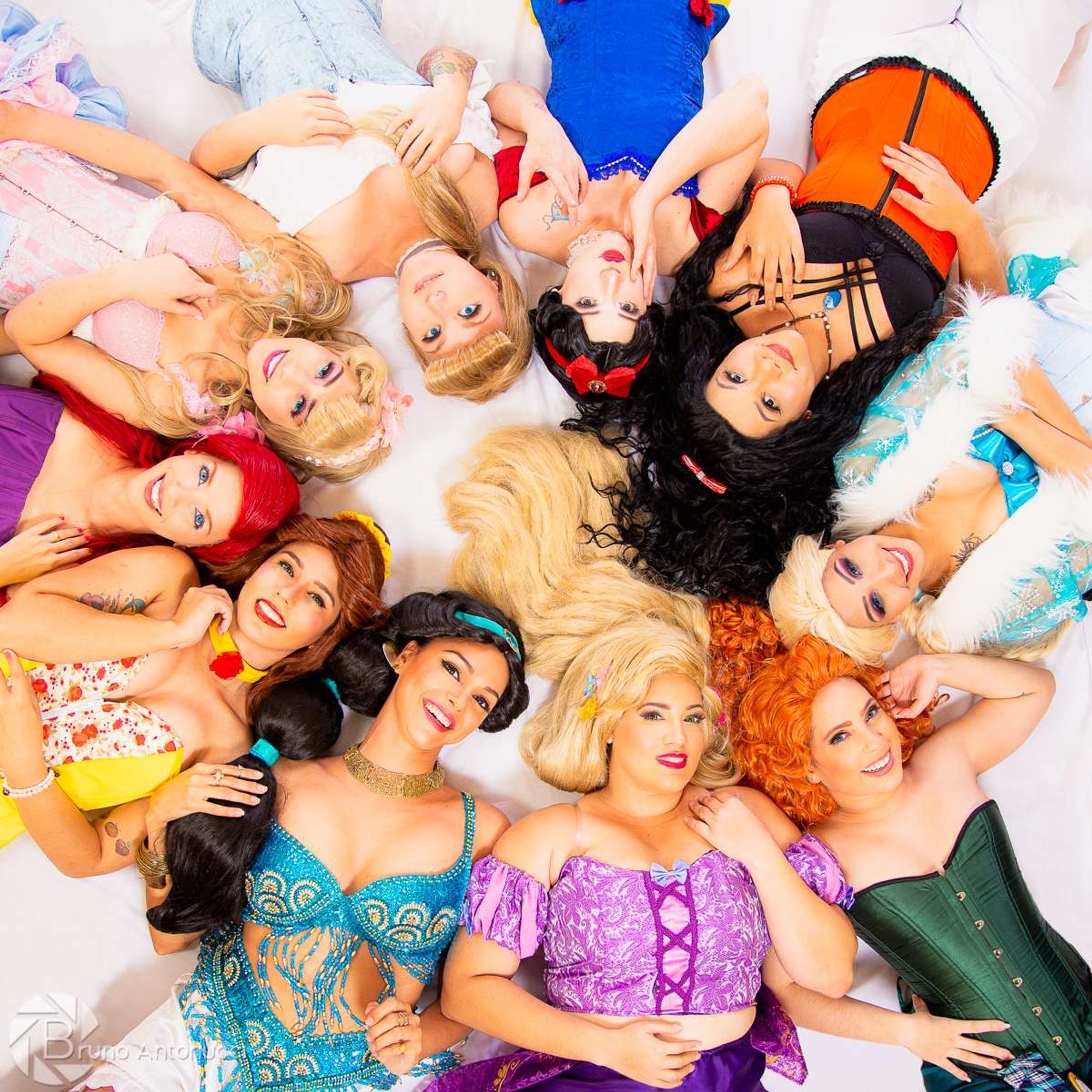 Uma foto com 10 mulheres com cosplay de princesas da disney usando corset e ceroulas.