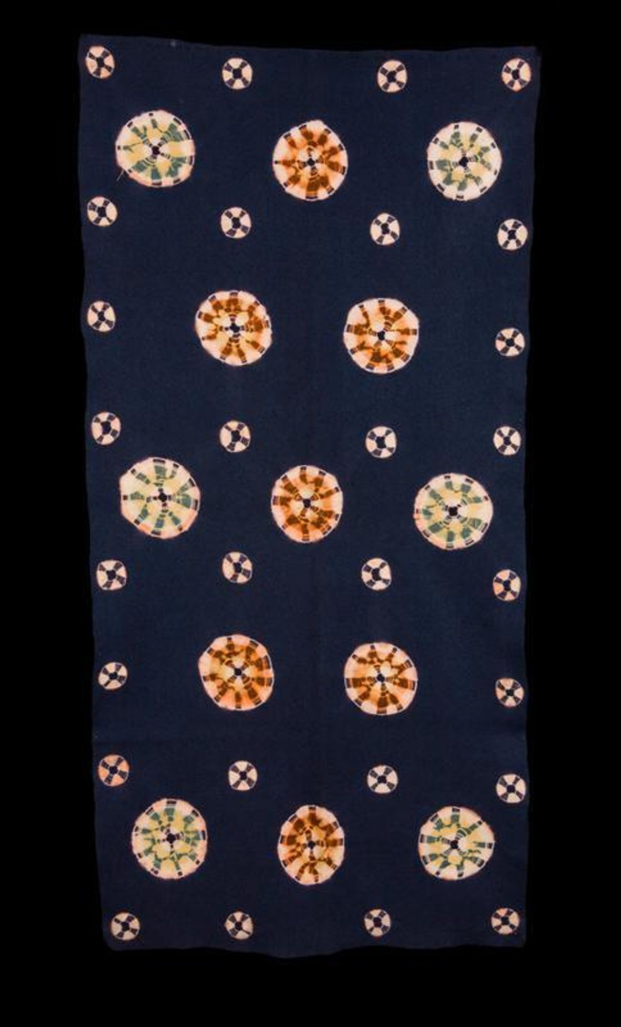 deep navy blue rug with round tie-dyed circles dispersed throughout in washy red and green colors
Fabric made in Mongolia for the Japanese market.