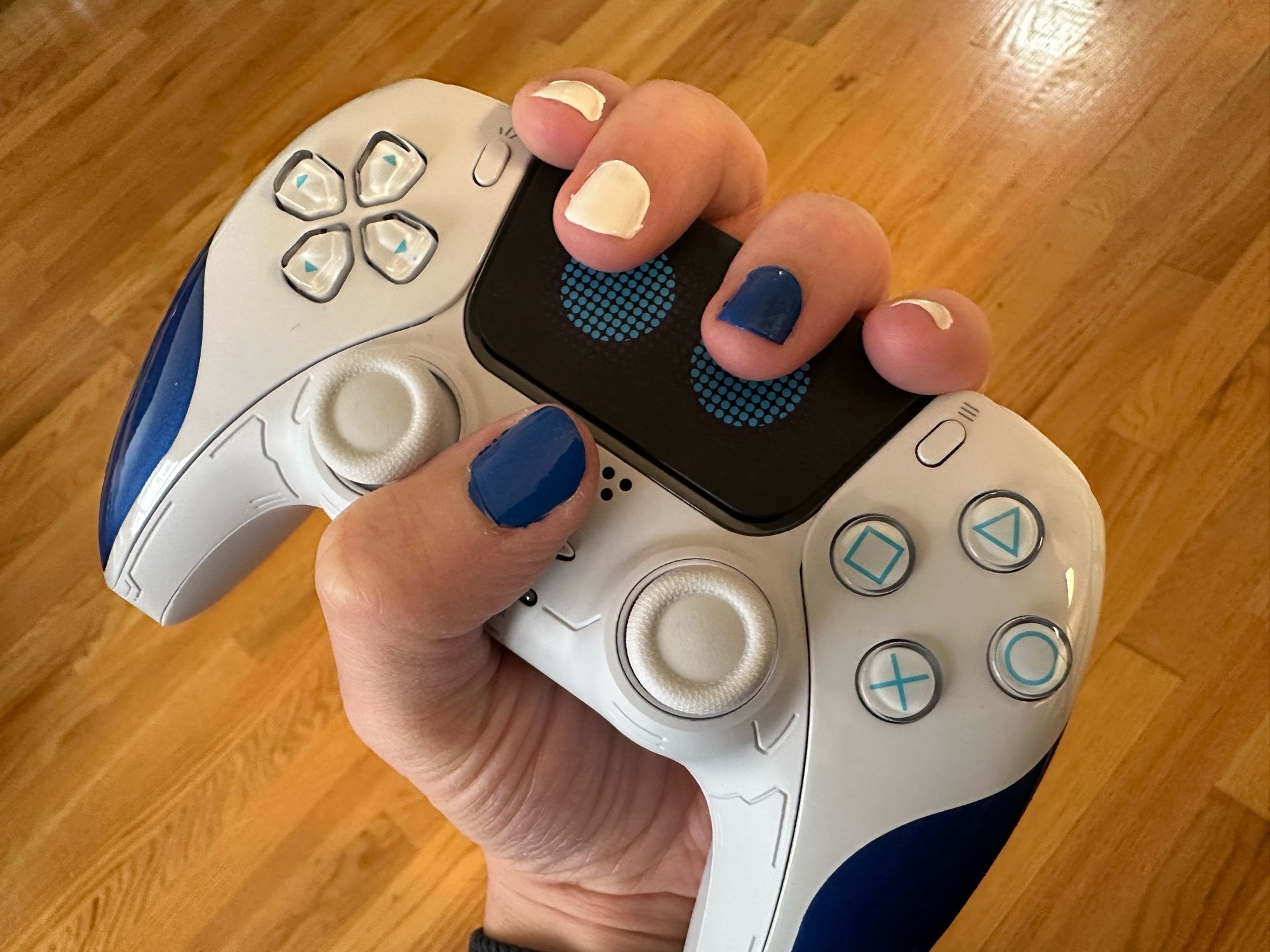 It’s my newly painted nails, white and blue, the colors of Astro Bot.  I’m holding an Astro Bot controller for reference.