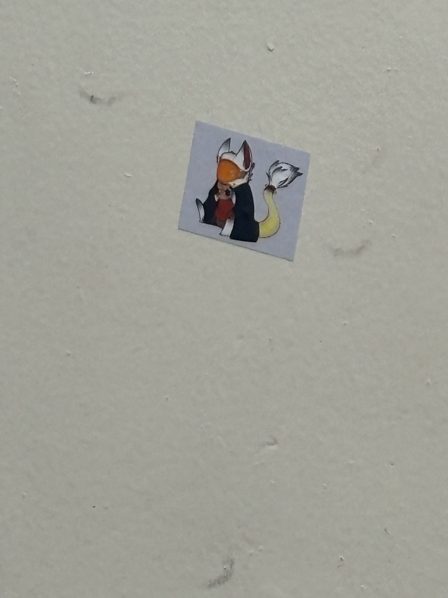 A sticker of a white furred protogen with a navy blue blanket drinking coffee from a fixit mug stuck to the wall of the previous picture of the squash court