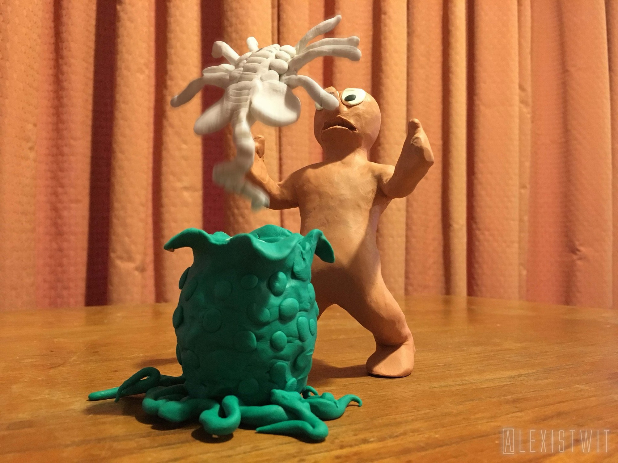 Morph rears back in terror as a white plasticine facehugger leaps out of the egg, its fingers reaching for his face