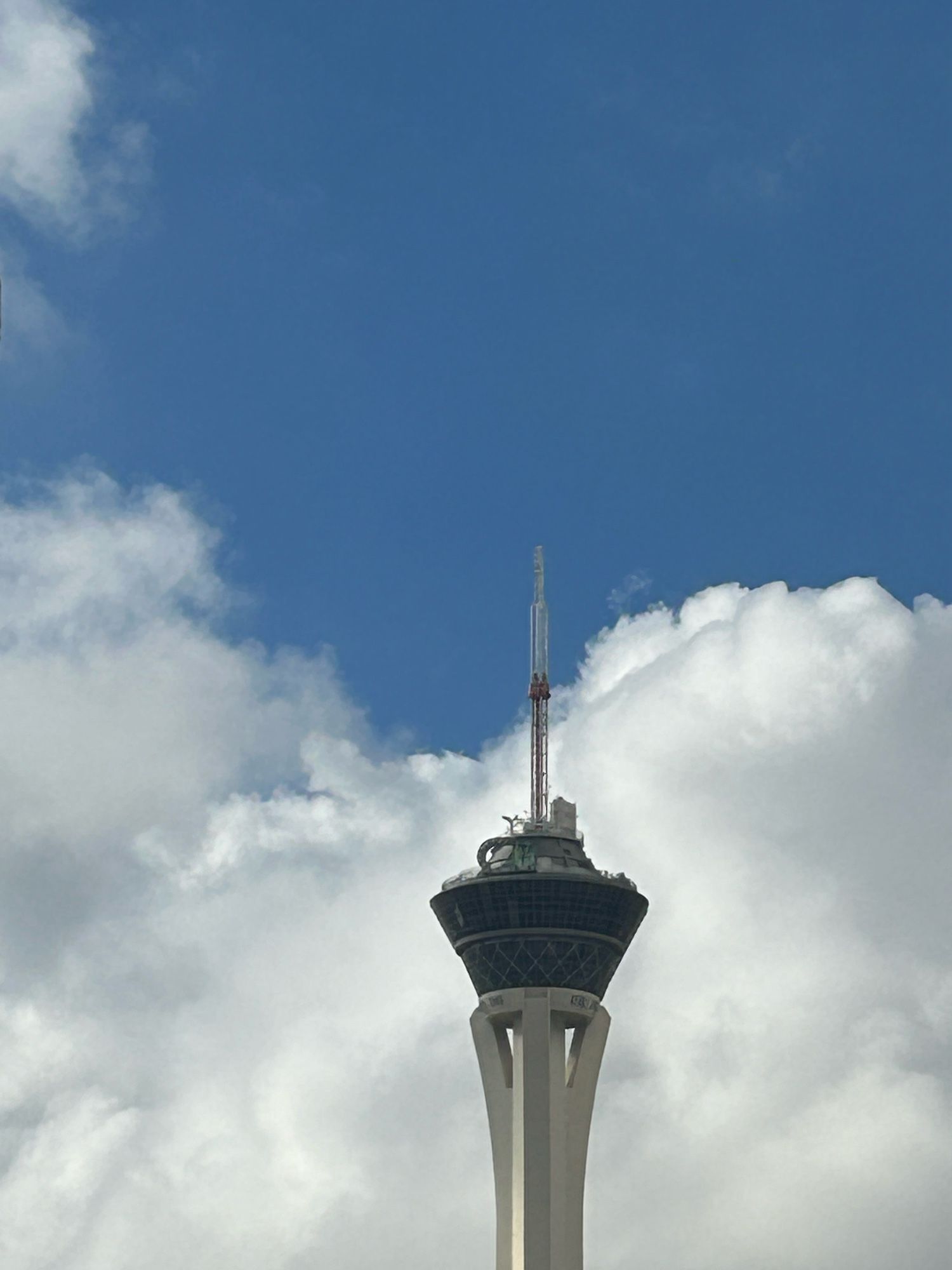 The Strat in Las Vegas against a background of fluffy white cumulus clouds and a grey-blue sky. Originally posted as a #skyfornamjoon project contribution.