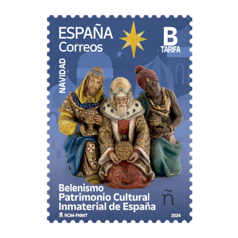 Sello Tarifa B de Navidad 2024 de Correos. En un fondo de tonos azules se aprecian dibujadas cúpulas.  En primer término, una imagen frontal de los Reyes Magos ofreciendo sus regalos. Encima aparece el dibujo de una estrella de ocho puntas. En la parte inferior el texto «Belenismo. Patrimonio Inmaterial de España».