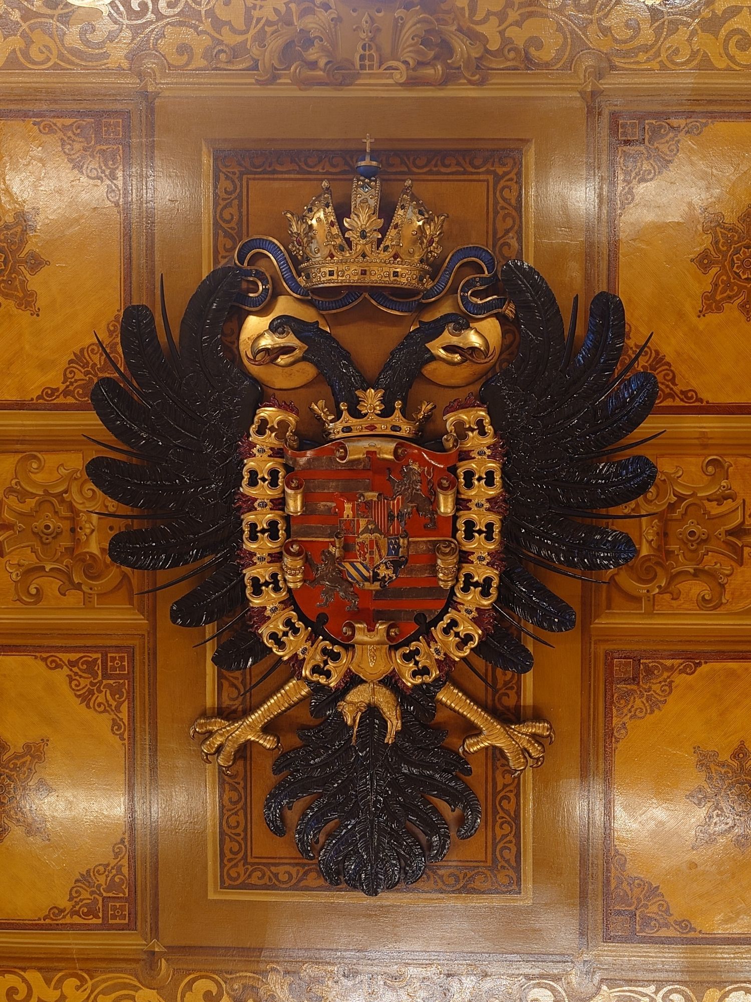 Habsburg family crest on wood paneled ceiling