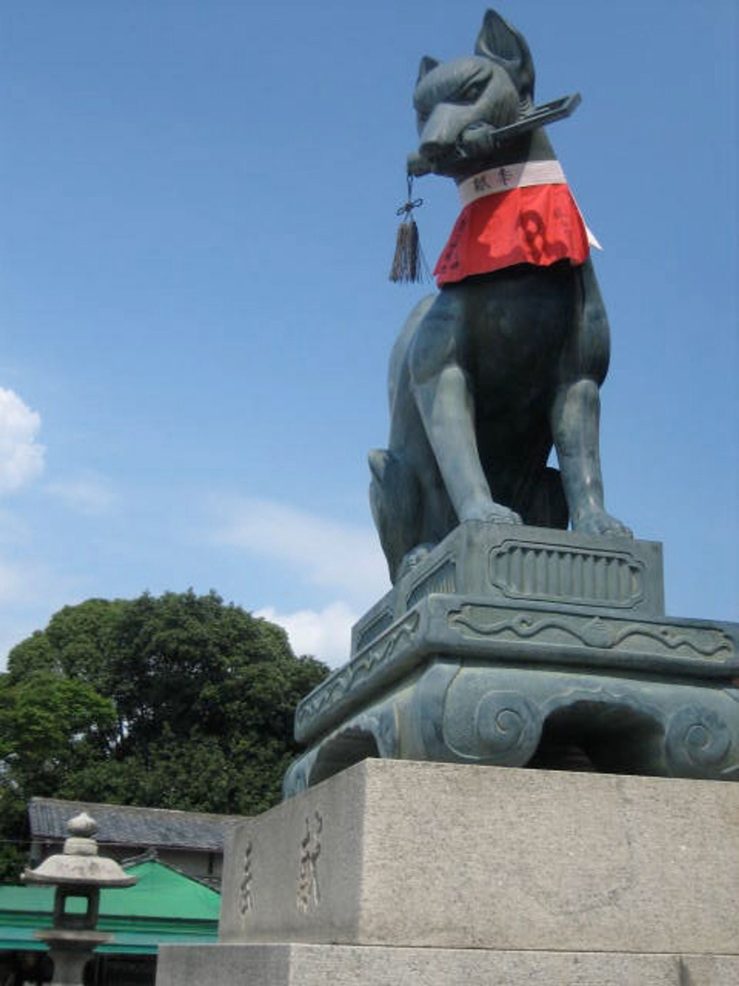 Fushimi Inari Shrine, specifically one of its gate kitsune, holding a key in its mouth.