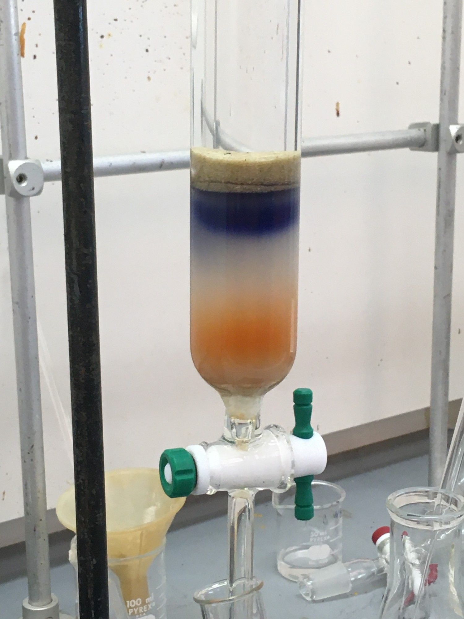 Silica gel column with a blue/purple band on top and an orange band on the bottom.