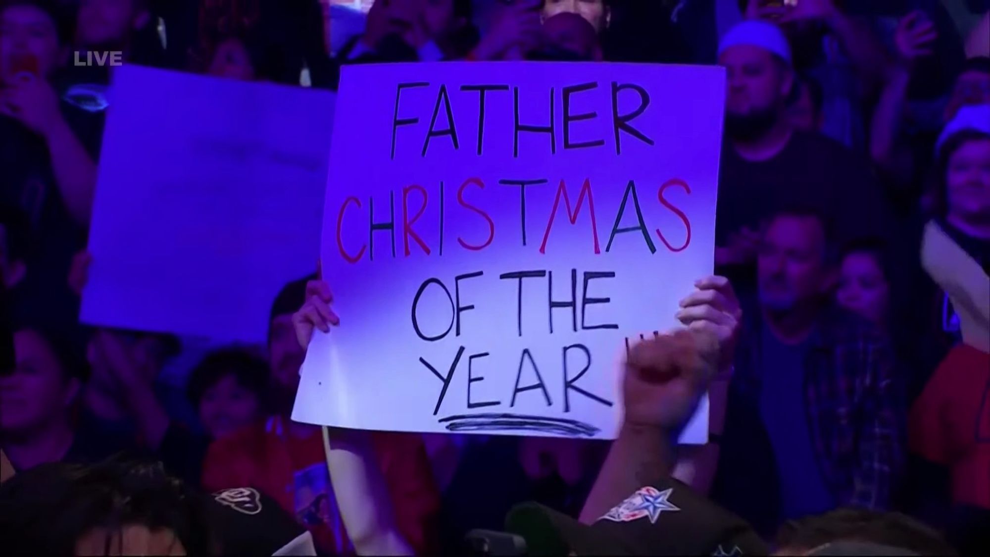 Sign says "FATHER CHRISTMAS OF THE YEAR"