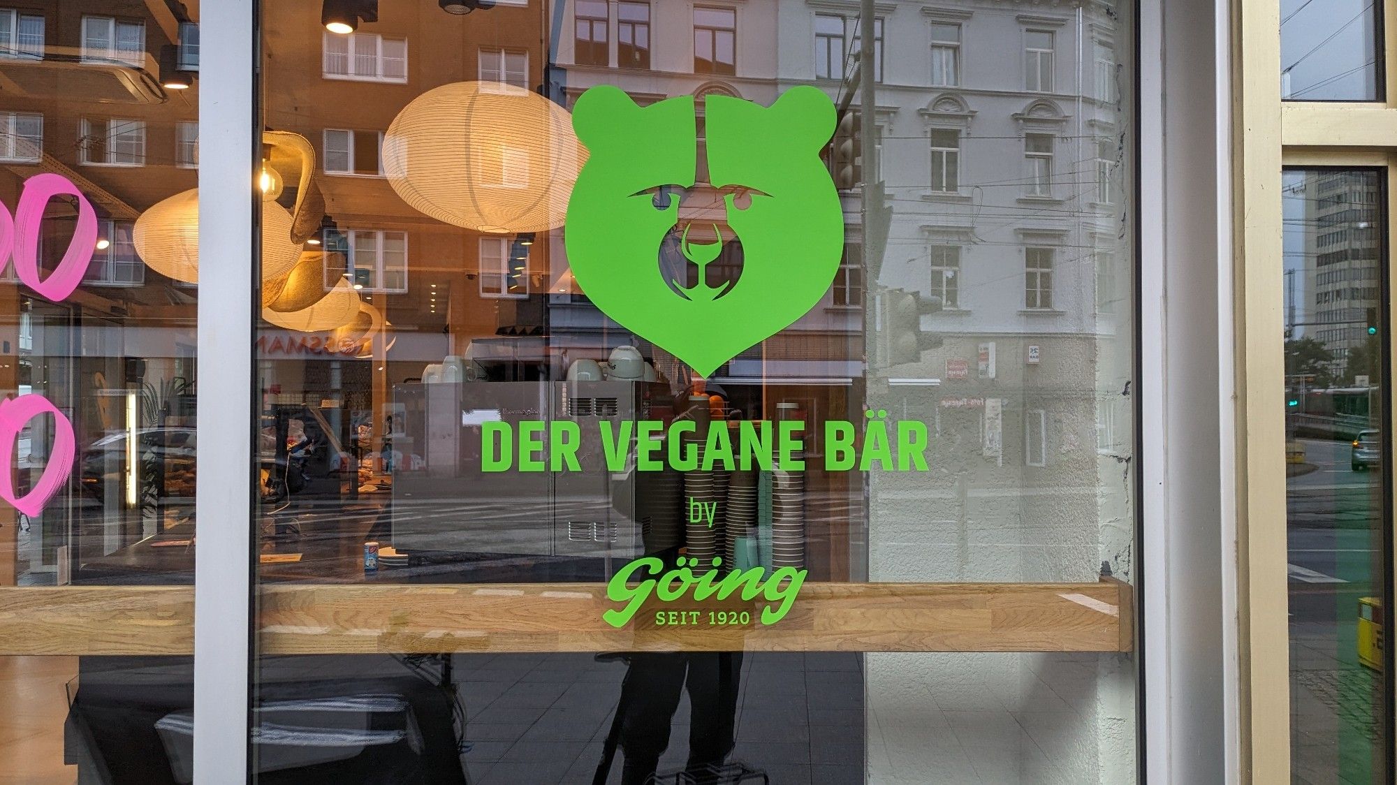 Foto vom Frontfenster: zu sehen ist ein grünes Logo eines Bärenkopfes.
Darunter steht in grüner Schrift: Der vegane Bär by Göing seit 1920