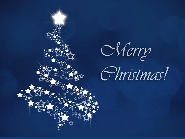 A white starry Christmas tree on a blue background beside the words Merry Christmas