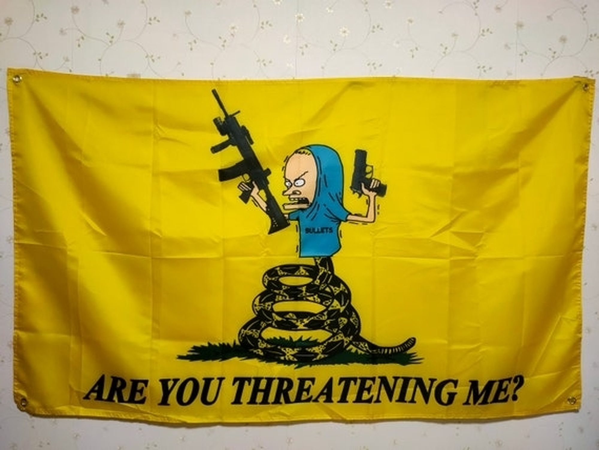 Beavis, as Cornholio brandishing an assault rifle and a handgun, pictured as the head of the snake on the Gadsden Flag with the line "Are you threatening me?"