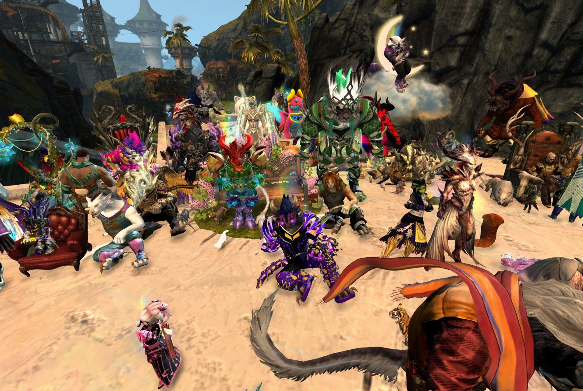 A Guild Wars 2 screenshot of the Tyria Pride Marchers sitting on the ground or in chairs at the Field of the Fallen. They are once again in their Pride flag colours