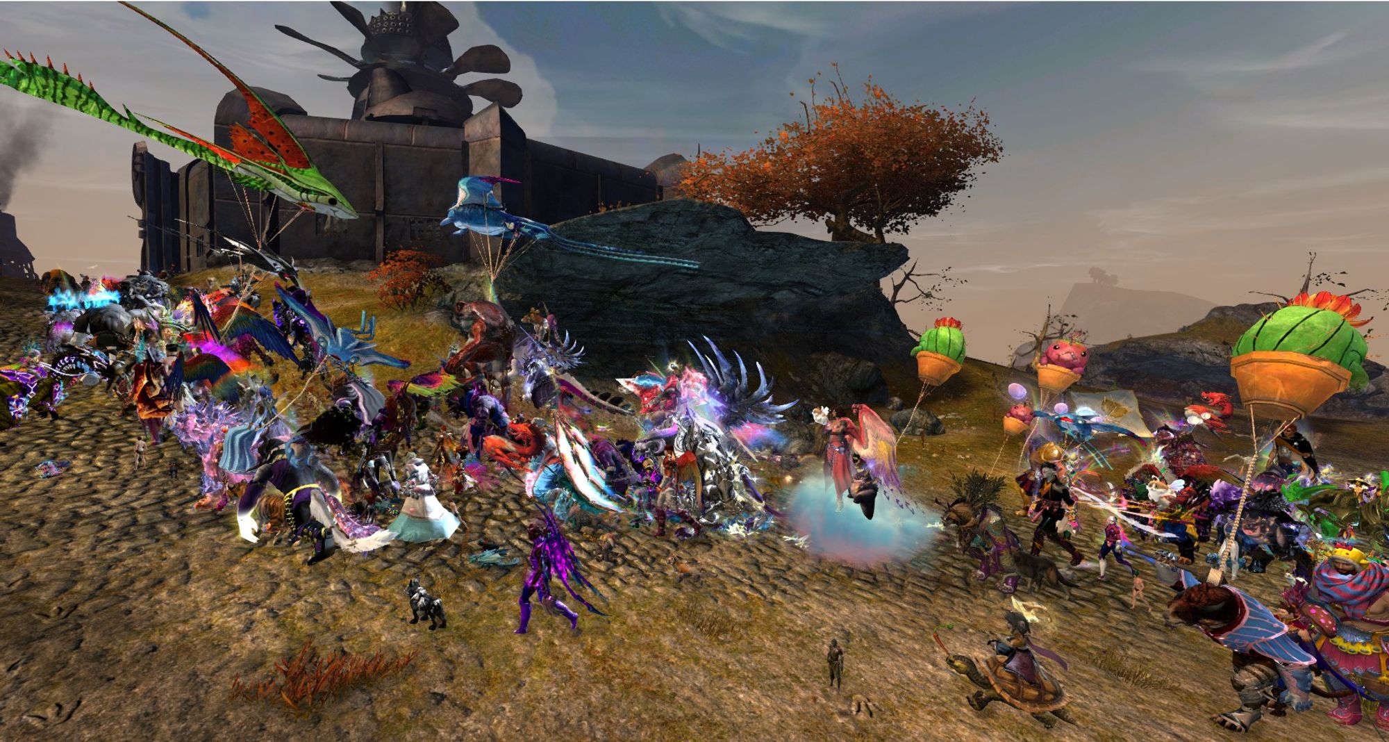 A Guild Wars 2 screenshot of the Tyria Pride March trekking through Ascalon, going past a metal Charr settlement.