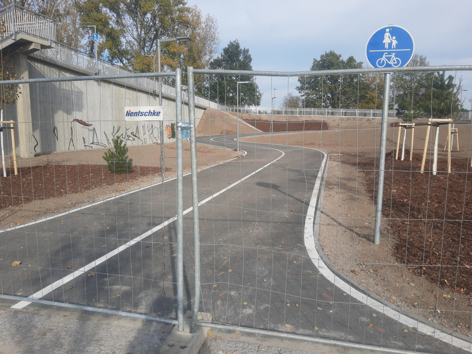 blick auf bUstelle einer fus- Radbrücke. Trennstrich in der Mitte des Weges, vorne rechts ein Verkehrszeichen für gemeinsamen Fuß- & Radverkehr VZ240