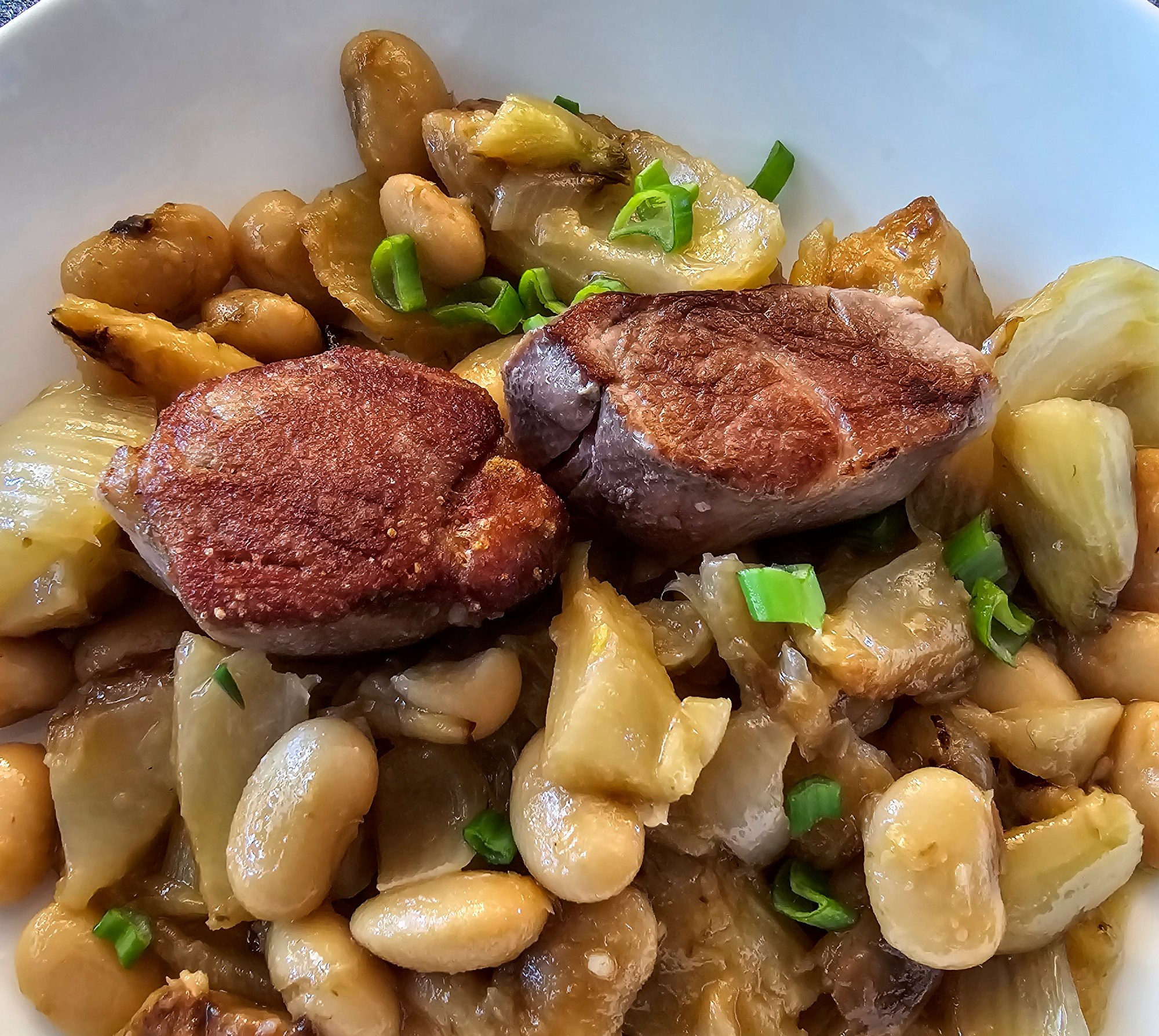 Seared pork medallions on a bed of braised fennel and butter beans