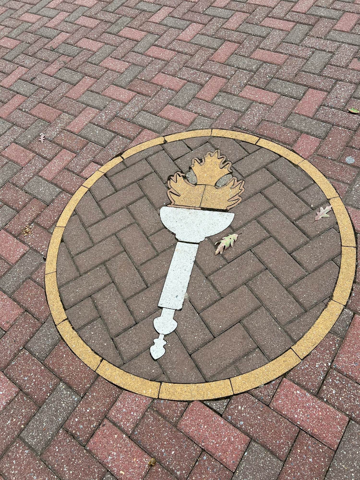 The logo of Rowan University built into the sidewalk pavers