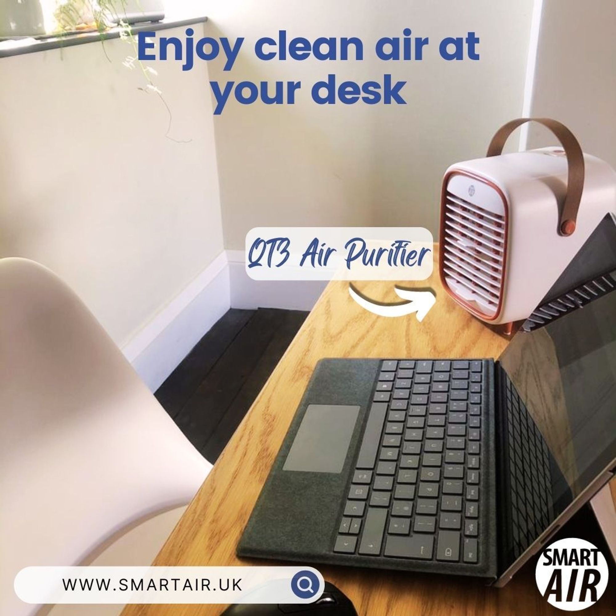  A compact, portable air purifier sits on a wooden desk beside a laptop, with a chair positioned nearby. The purifier is labeled as the “QTB Air Purifier,” and the text promotes its use for enjoying clean air at your desk. The Smart Air logo and website link are visible.