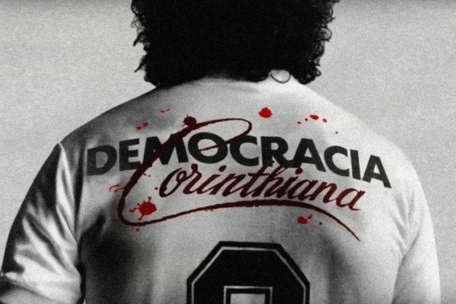 Homem, de costas, com cabelos escuros utilizando uma camisa com o símbolo da Democracia Corinthiana. Créditos: Divulgação / Corinthians, em post das eleições de 2018.