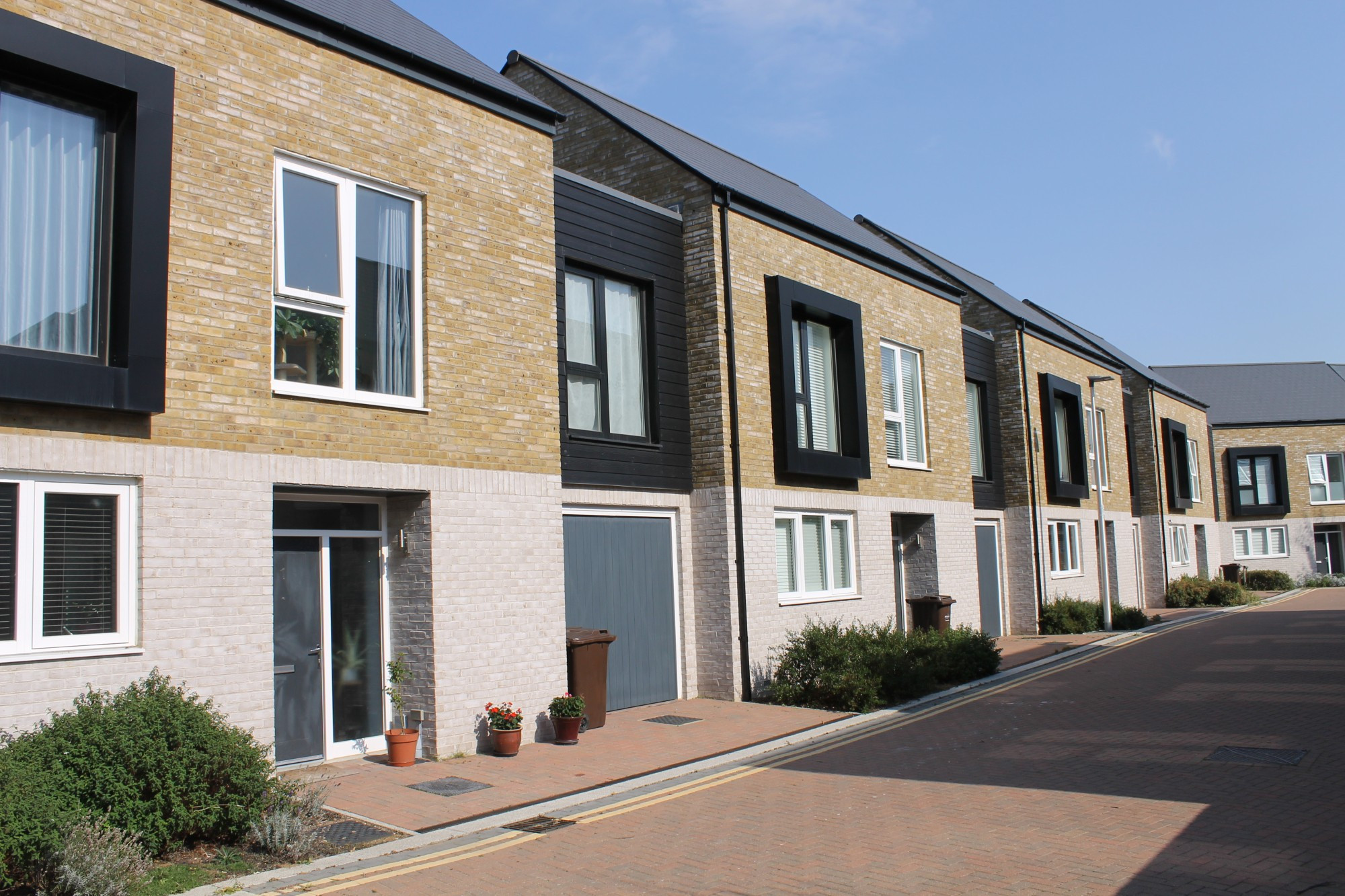 2 storey terraces with garages. Large framed first floor room windows make a good rhythm along the short cul de sac