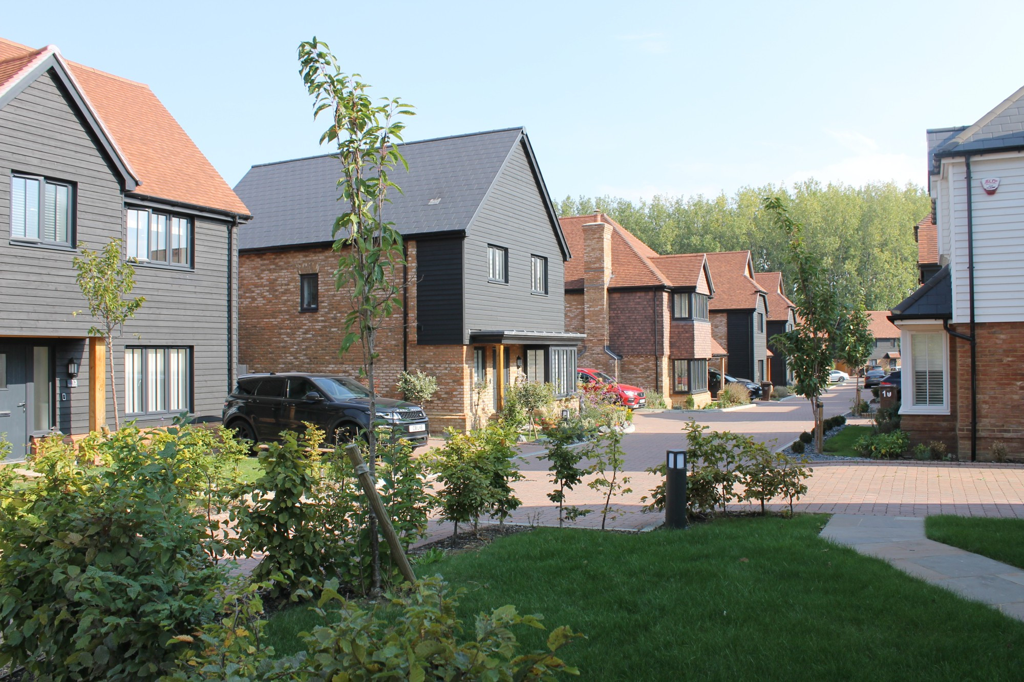 part weatherboarded detached houses along block paved street