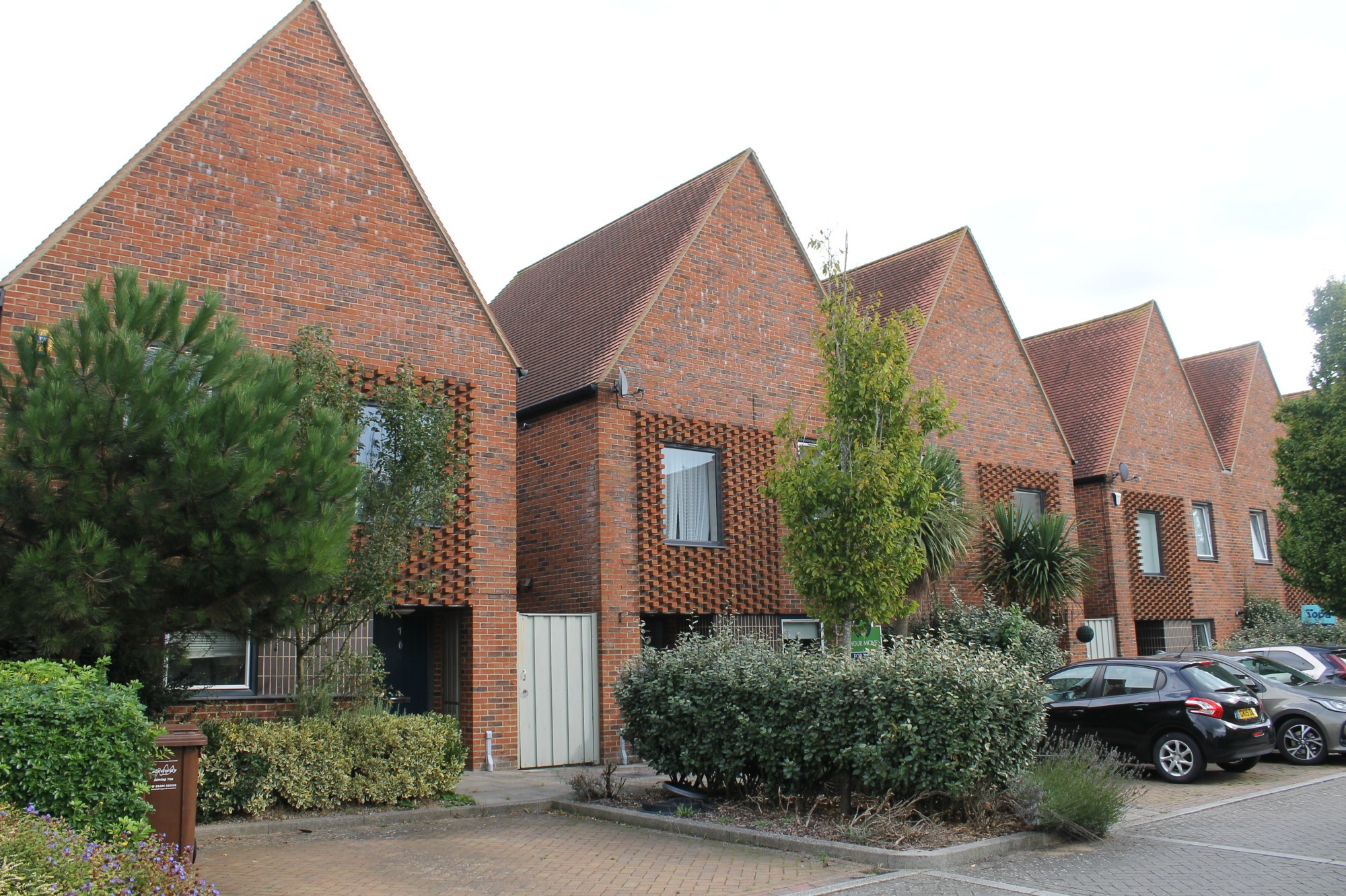 gable ended 2 storey brick homes with parking to front. Southern beech trees line the street