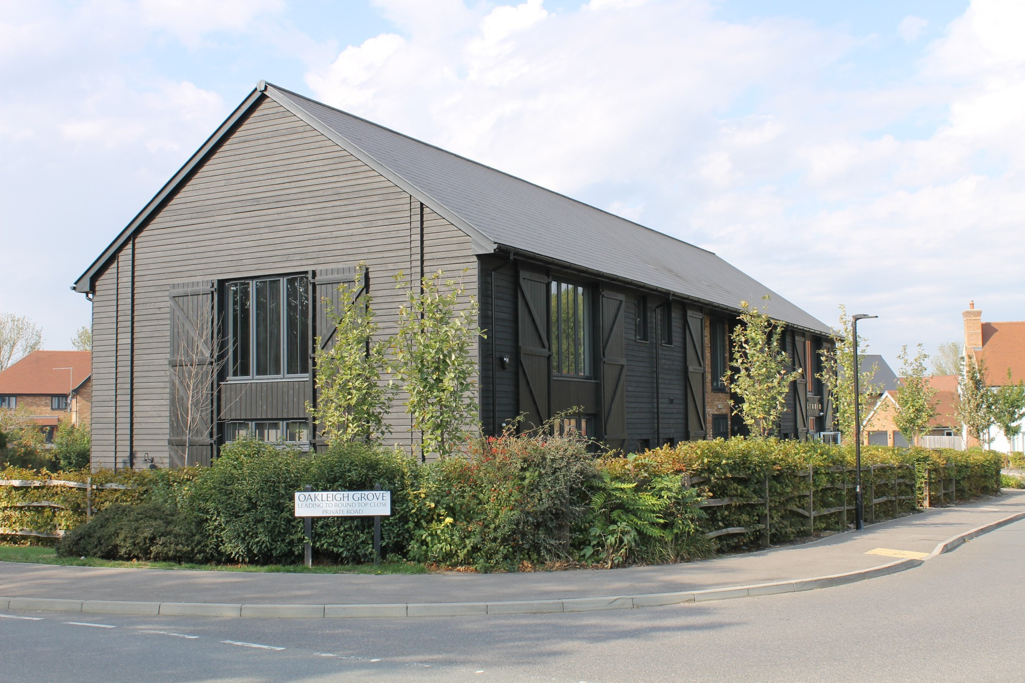 black weatherboarded 2 storey commercial barn building with workshop/ studios