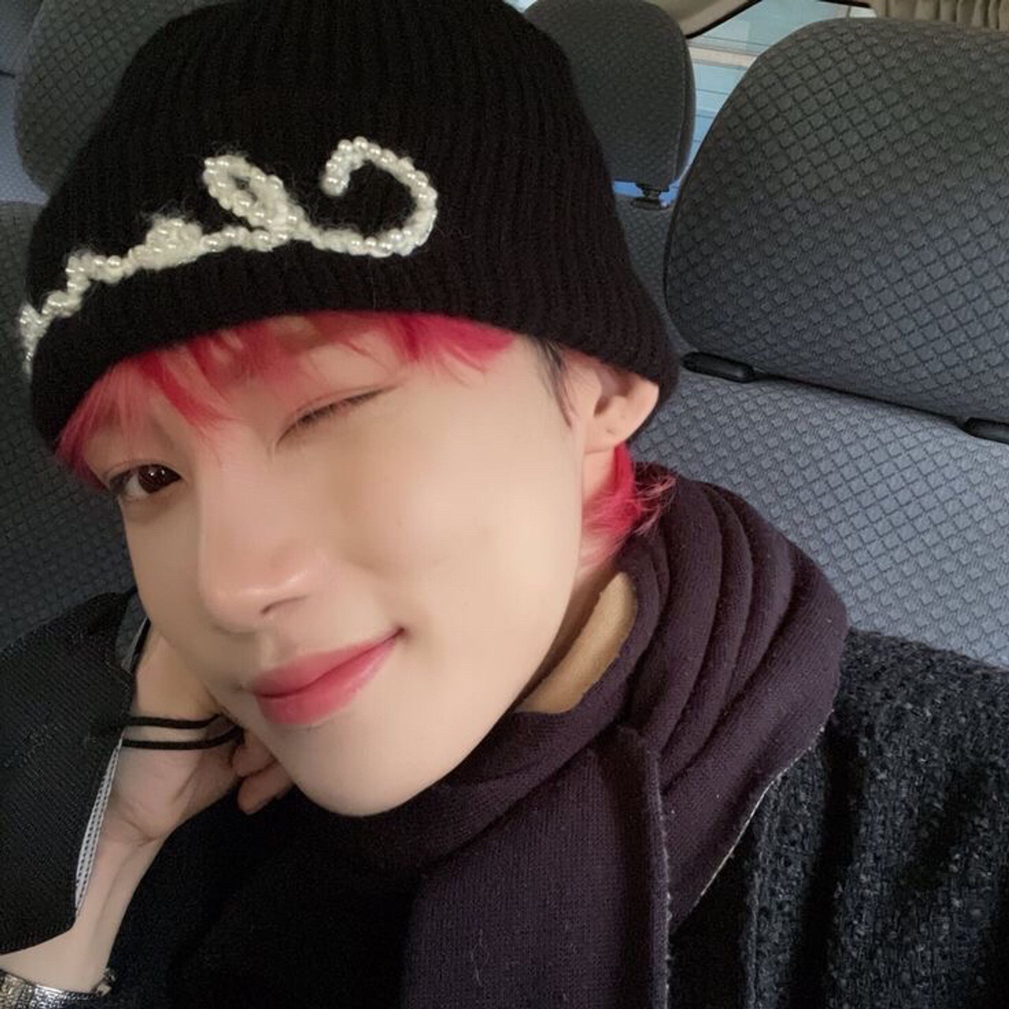 chanhee aka new taking a selfie, winking at the camera, wearing a chanel beanie with red hair poking out from underneath it