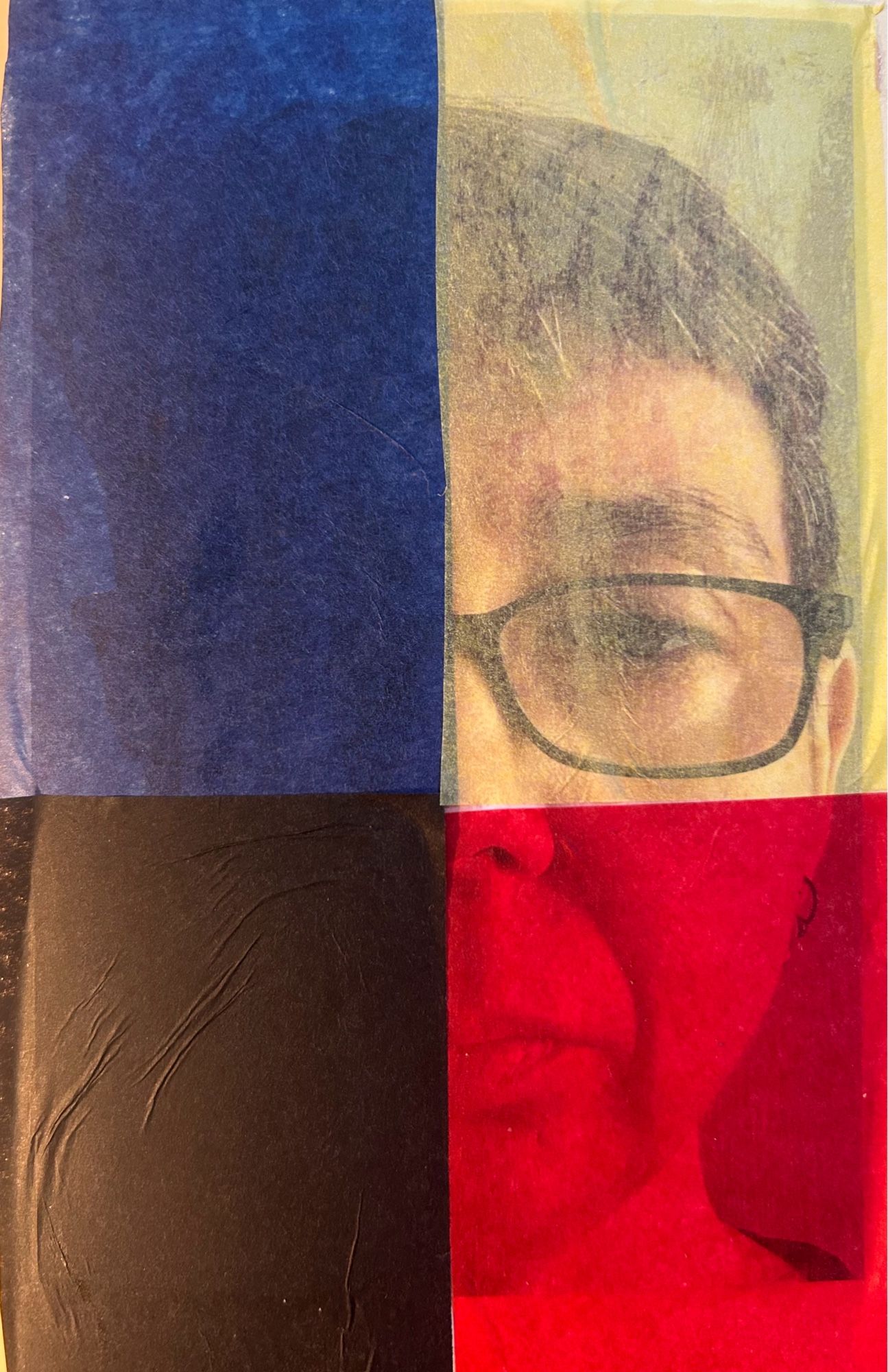 Picture of a white woman’s face. She has short brown hair and rectangular glasses with dark frames. Each quadrant of her face is covered by a piece of tissue paper, yellow, red, blue, and black, some more translucent than others