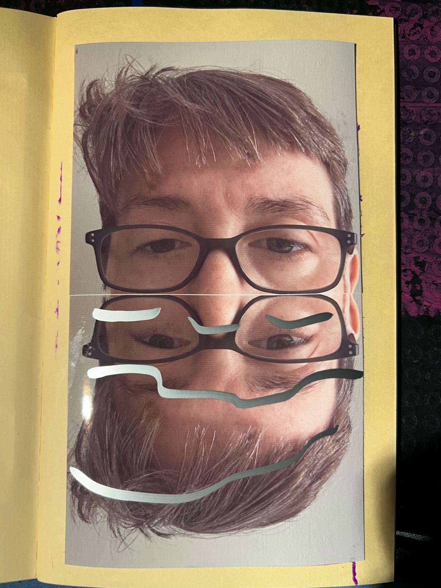 The upper portion of the face of a  white woman with short brown hair and rectangular glasses with dark frames rises above itself as if reflected in water. Silver paint marker on the lower half of the image furthers the impression of reflectivity.