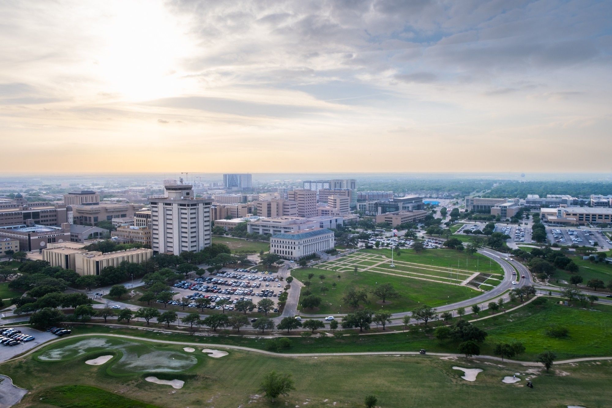 Aerial of campus at sunset showing the Admin Building and the front of campus.