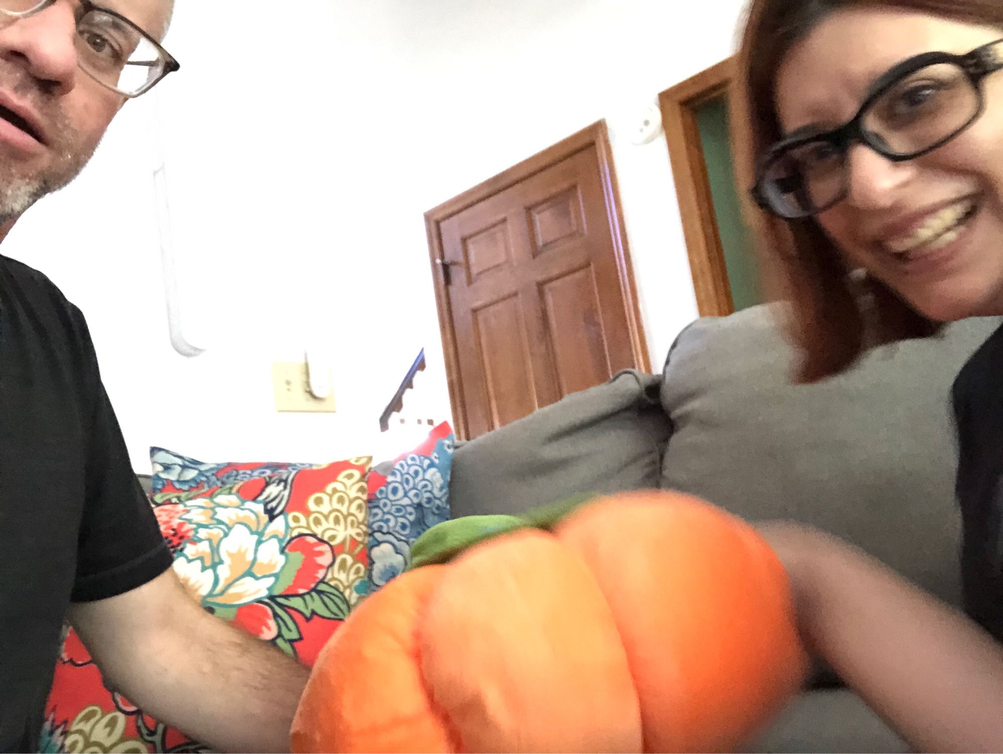 A middle aged man and a middle aged woman, wrist deep in a stuffed pumpkin