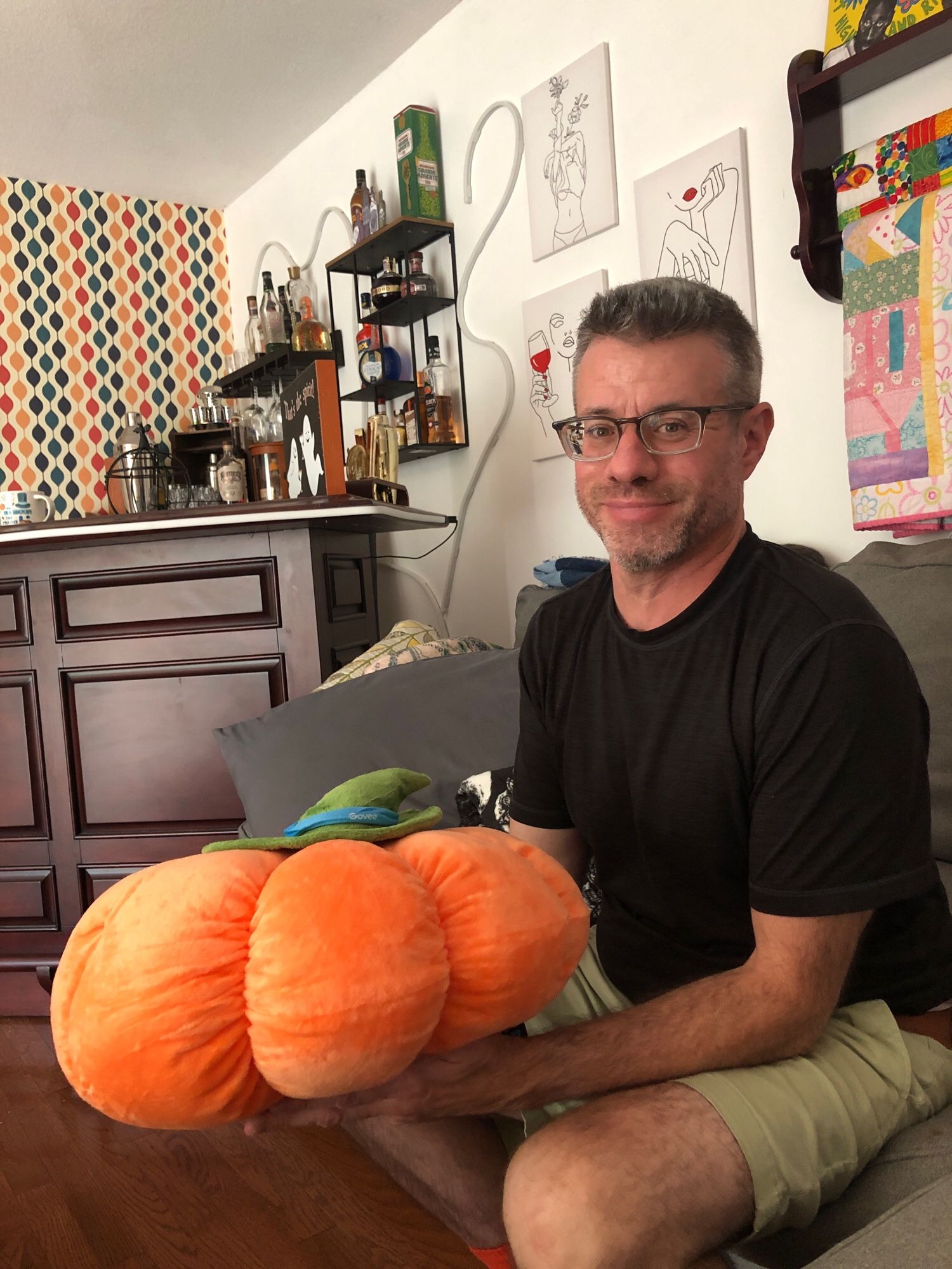 A middle aged man holding a large stuffed pumpkin