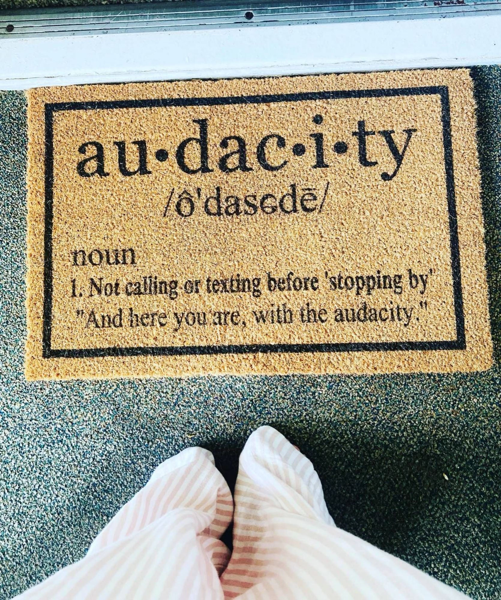 Picture of welcome mat with text:

au-dac-i-ty
o'dasede
noun
1. Not calling or texting before 'stopping by
"And here you are, with the audacity.