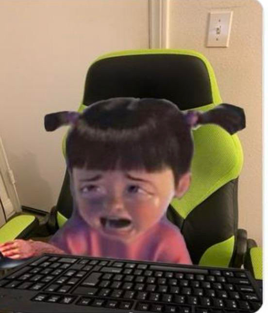 boo from monsters inc sobbing while sitting in a gaming chair with a keyboard in front of her