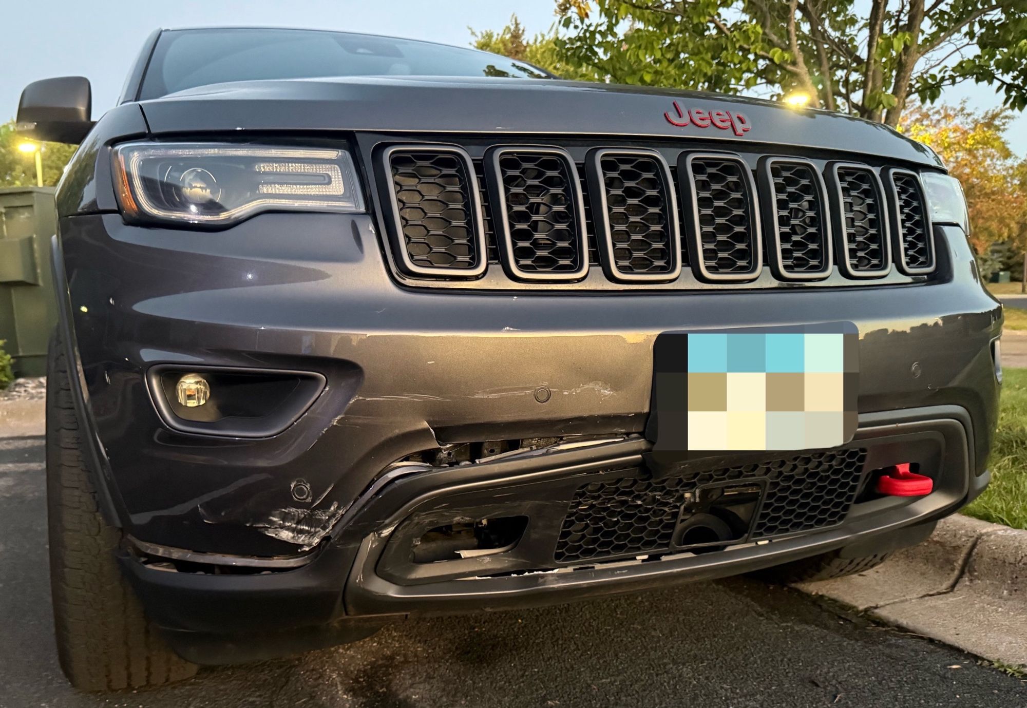 Front end damage to dark suv caused by vehicle collision.