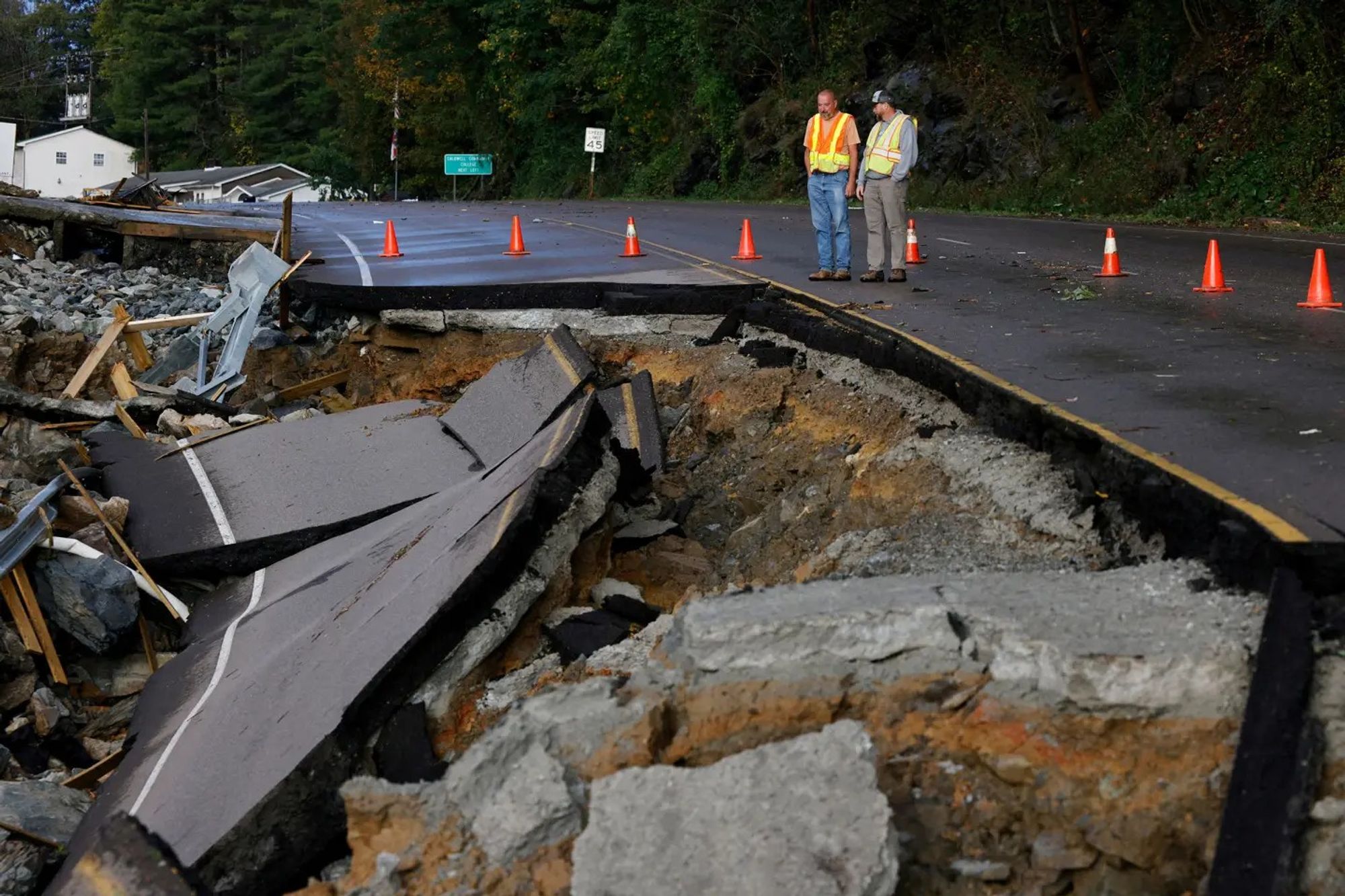 Workers survey a large section of Highway 105 that washed away because of flood waters, on the outskirts of Boone, N.C., on Sept. 27.Jonathan Drake—Reuters