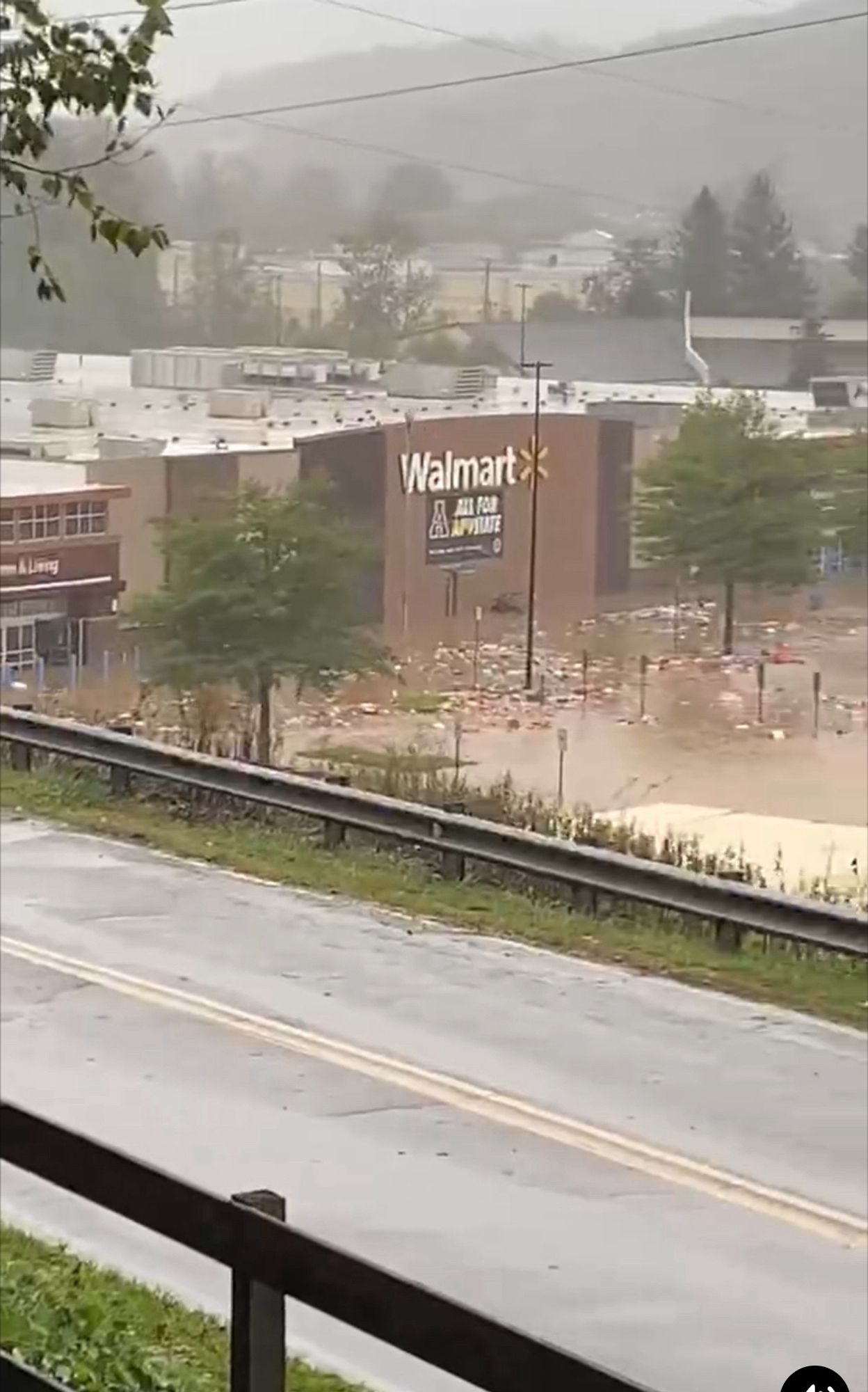 A flooded Walmart with goods streaming into the parking lot.