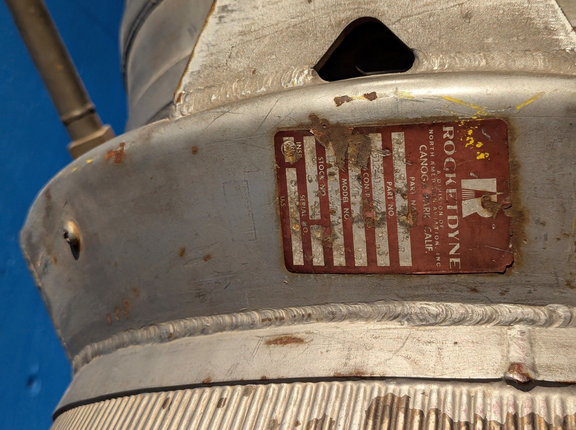 Rust colored Rocketdyne label on the outside of a silver colored combustion chamber