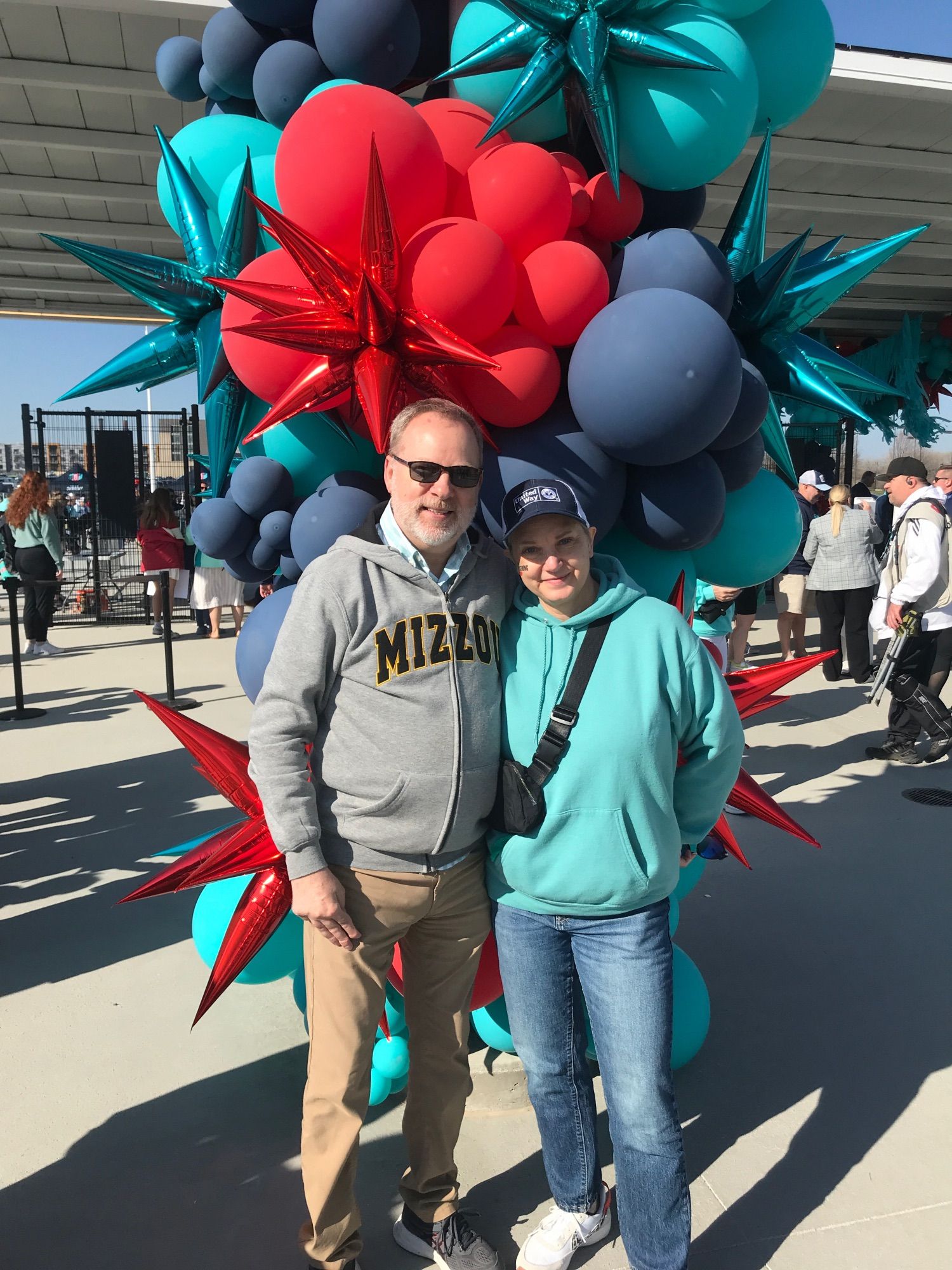 My wife and I stand in front of a spectacular balloon installation in KC Current team colors outside CPKS Stadium in Kansas City, Missouri