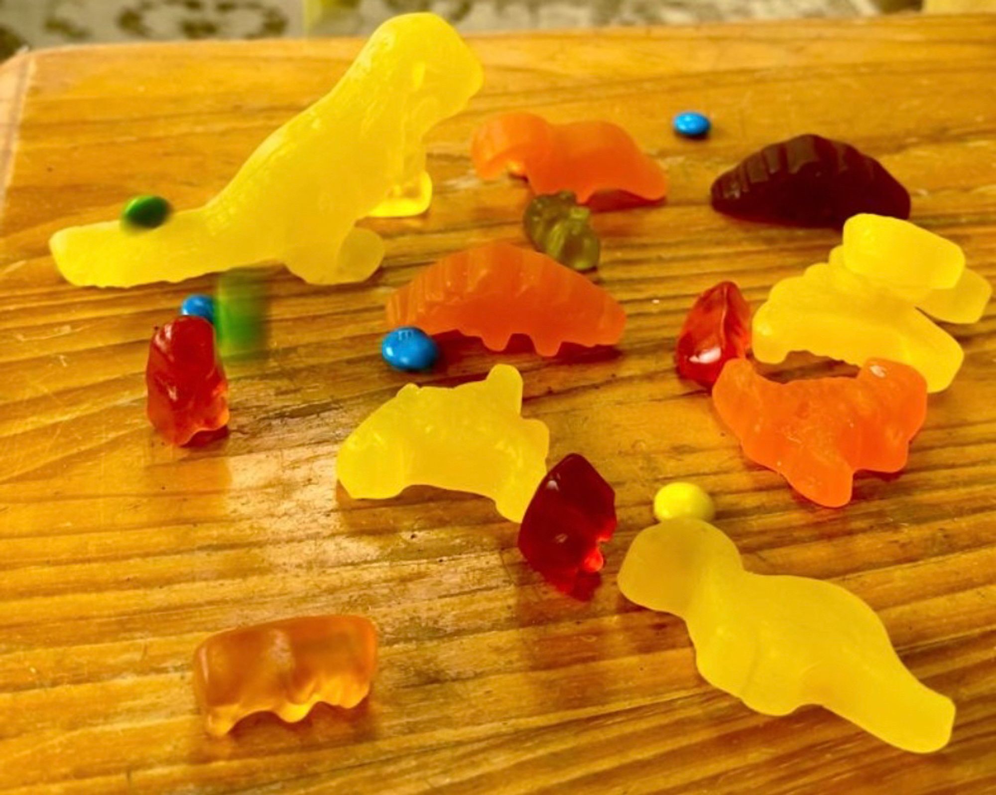 Gummy dinosaurs and gummy bears on top of a table. Many are dead. The few survivors are struggling against a torrent of comet m n ms. It's all very colourful.
It's a masterpiece.