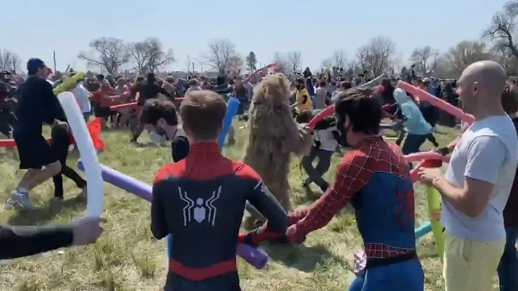 bunch of people dressed in different costumes fighting with like spongy poles things