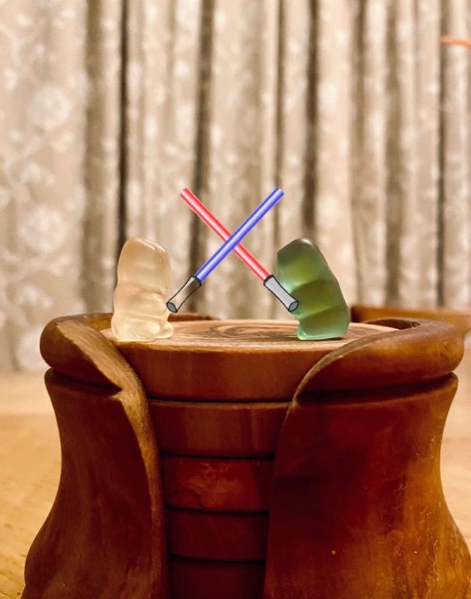 Two gummy bears standing on top of a wooden coaster stand. I photoshopped a red and blue lightsaber into their hands.
It's a masterpiece and really captures the essence of the original scene