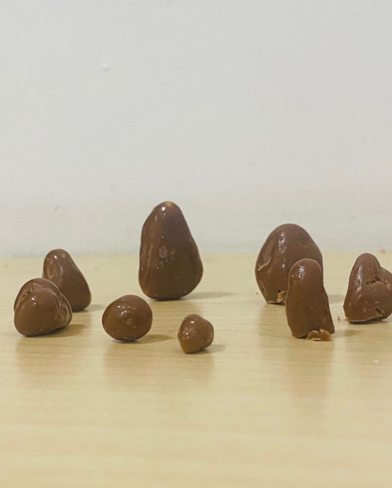 Chocolate raisins of all shapes and sizes placed in a circle. Some wouldn't stand up so I had to bit of the bottom to make them stand. there on a table.