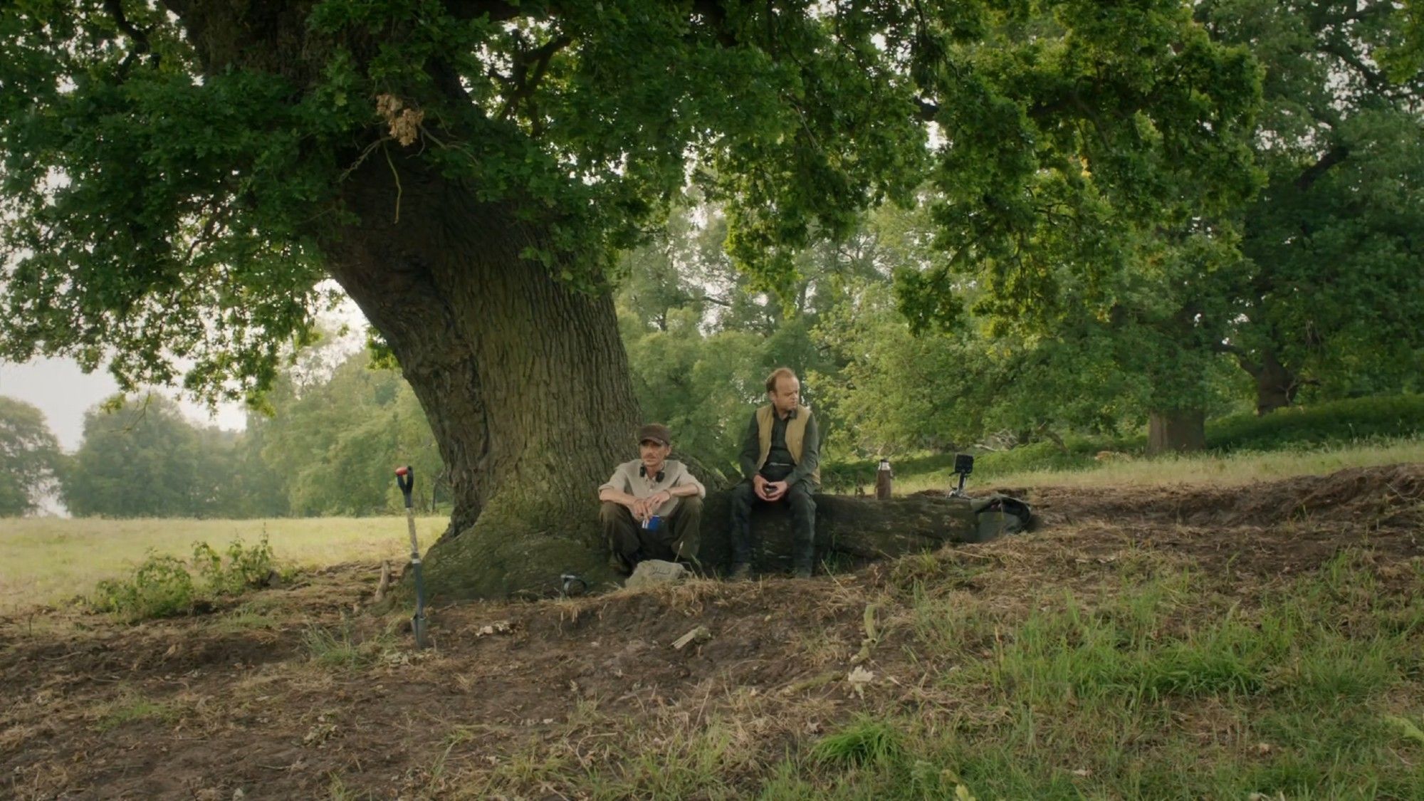 The characters of Lance and Andy sitting beneath an oak tree, during a break from detecting.