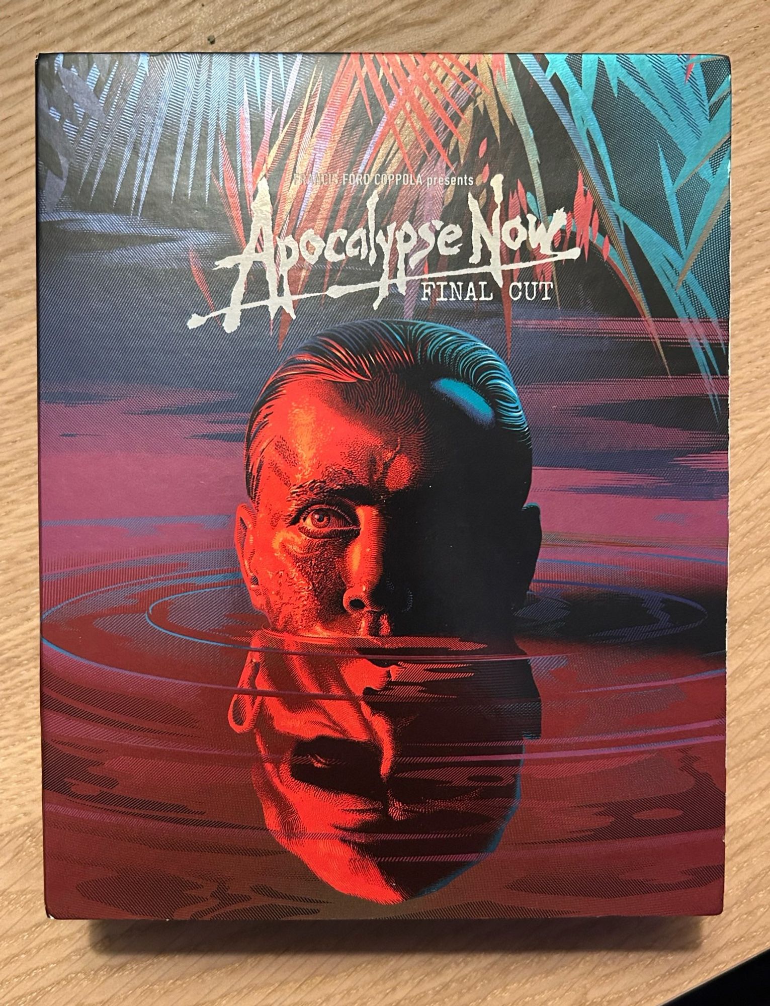 Cover of Apocalypse Now: The Final Cut with Martin Sheen’s head coming out of the water, reflected by Marlon Brando’s head in the water.