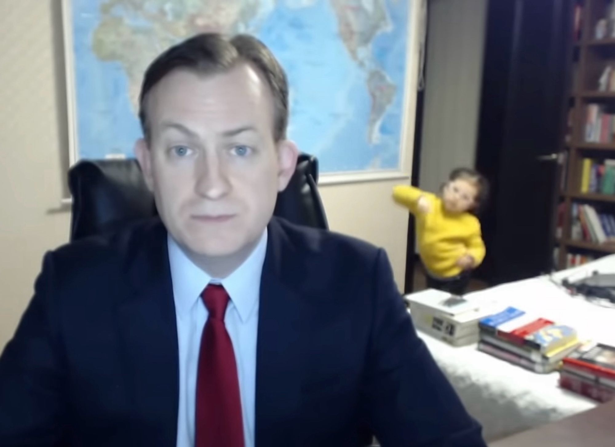 BBC journalist Robert Kelley broadcasting from his home office during the pandemic as his child dances in the background