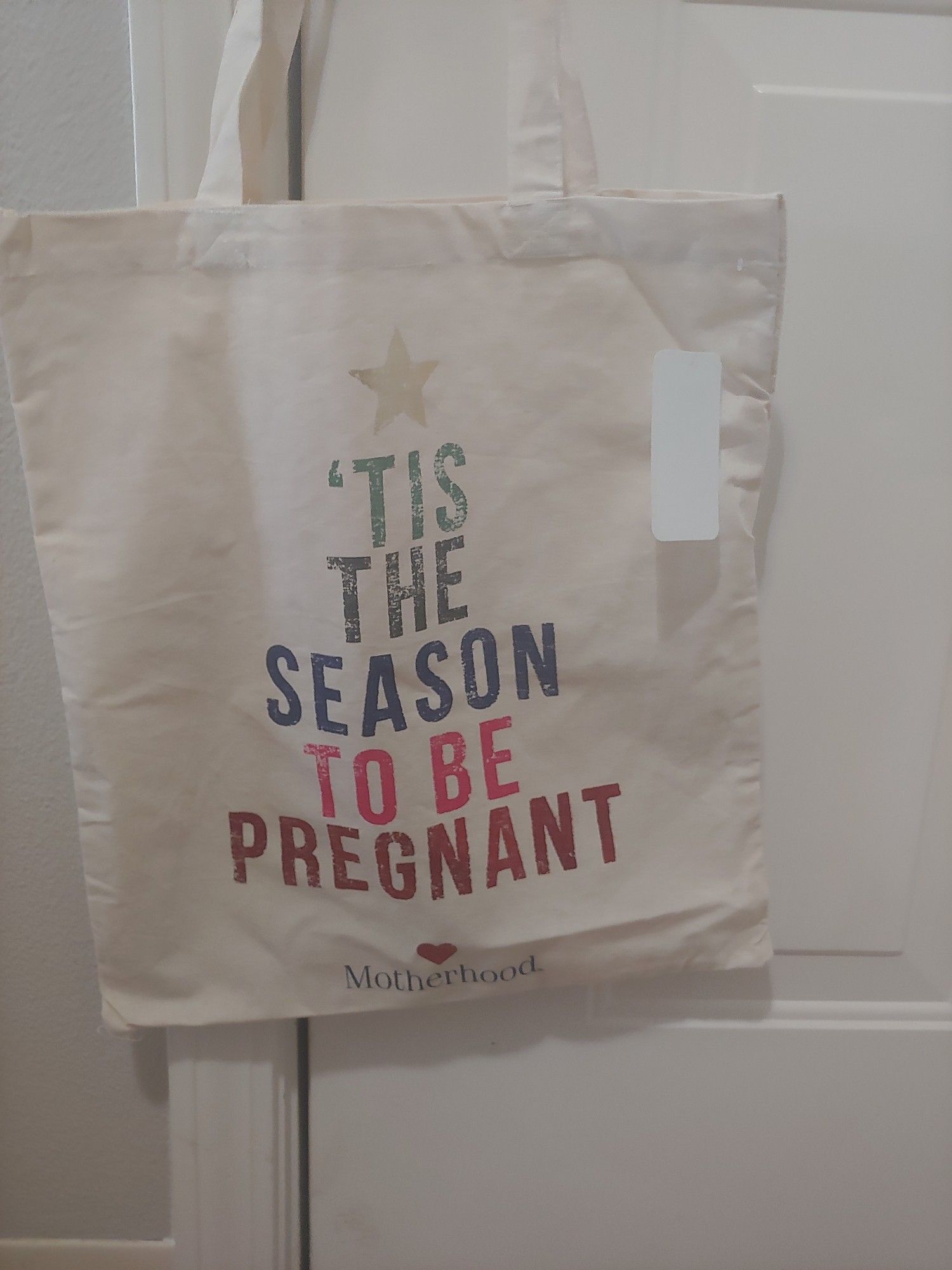 Handbag that says "Tis the season to be pregnant"